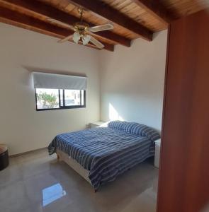 1 dormitorio con 1 cama y ventilador de techo en León I en Mendoza