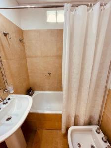 y baño con lavabo, bañera y cortina de ducha. en Alojamiento corrientes en Corrientes