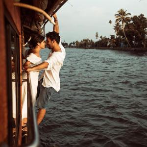 un hombre y una mujer en un barco en el agua en Kera Houseboats Alleppey, en Alleppey