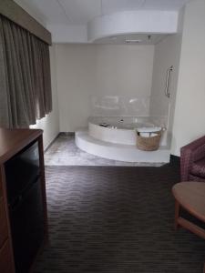 een kamer met een bad in de hoek van een kamer bij AmericInn by Wyndham Red Wing in Red Wing