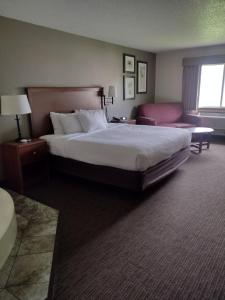 レッド・ウィングにあるAmericInn by Wyndham Red Wingの大きなベッドとソファが備わるホテルルームです。