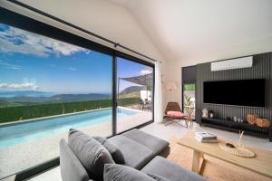 sala de estar con sofá, TV y piscina en Villa Oxy Private Pools & Seaview & Heated Indoor Pool, en Göcek
