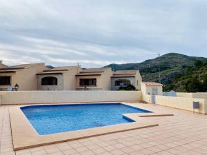 une grande piscine en face d'une maison dans l'établissement Apartamento Pàmpol, à Lliber