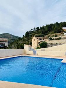 une grande piscine bleue en face d'un bâtiment dans l'établissement Apartamento Pàmpol, à Lliber