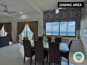 a dining room with a table and chairs and windows at Sky2Sea Penthouse @ Icon Residences in Kuala Terengganu
