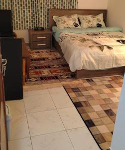 a bedroom with a bed and a tiled floor at SMD Comfy Apartments in Abu Dhabi