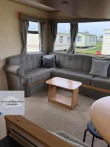 ein Wohnzimmer mit einem Sofa und einem Tisch in der Unterkunft Skegness - Ingoldmells Caravan Hire in Ingoldmells