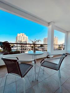 een tafel en stoelen op een balkon met uitzicht op de stad bij Alojamiento corrientes in Corrientes