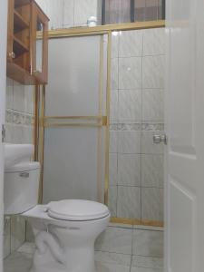 y baño con aseo blanco y ducha. en Comfortable 3-Bedroom Condo in Bellavista, Guayaquil, en Guayaquil