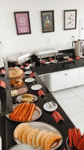 Ein Haufen Hot Dogs auf Tellern auf einer Theke. in der Unterkunft Hotel Executivo Boulevard in Mossoró