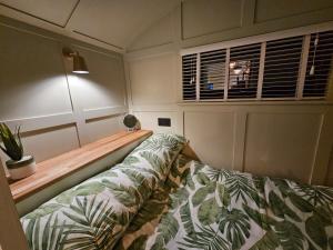a room with a bed and a window and a couch at Gatwick Hideaway Hut in Charlwood