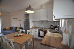 a kitchen and living room with a table and a dining room at Zennova #24, FLOW Nikiti Family Apt in Nikiti