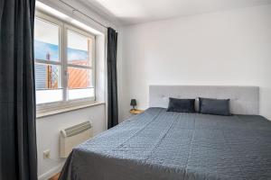 a bedroom with a bed with blue pillows and a window at Baltic Suite 16 in Stakendorfer Strand