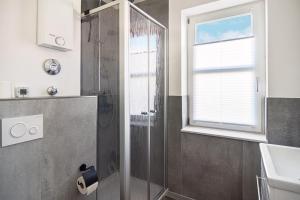 a bathroom with a shower and a sink and a window at Baltic Suite 16 in Stakendorfer Strand +17 photos