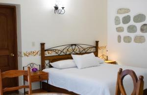 a bedroom with a bed and a table and a chair at Casa los Cantaros Hotel Boutique in Oaxaca City