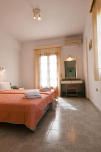 Pokój hotelowy z 2 łóżkami i umywalką w obiekcie Chrys Marie Studios w mieście Iraion