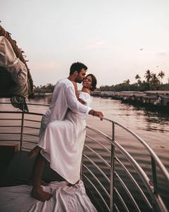 un hombre y una mujer de pie en un barco en Kera Houseboats Alleppey, en Alleppey