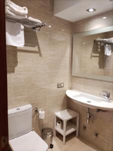 La salle de bains est pourvue de toilettes blanches et d'un lavabo. dans l'établissement Apartamentos Santana, à Llanes