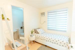 a small bedroom with a bed and a window at DGM AirBnB Urdaneta Pangasinan in Bayaoas