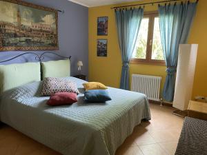 ein Schlafzimmer mit einem Bett mit Kissen darauf in der Unterkunft LunaSole Casa vacanza mare in Aprilia Marittima + 37 Fotos