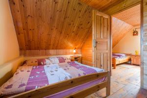 a bedroom with a bed with a wooden ceiling at Domek Bogdanka in Polańczyk