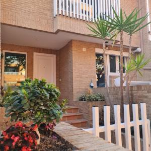 a white fence in front of a house with plants at Villa VegaLira in Valencia