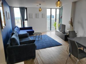 ein Wohnzimmer mit einem blauen Sofa und einem blauen Teppich in der Unterkunft Luxury Apartment Retreat - FREE Netflix And Wifi in Birmingham