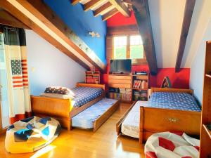 2 Betten in einem Zimmer mit blauen und roten Wänden in der Unterkunft Casona cantabra con piscina a 3 km de playas. Ideal familias. in Liencres