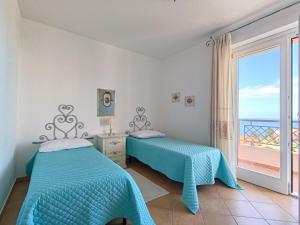 two beds in a bedroom with a view of the ocean at Splendida vista sul mare in Nebida