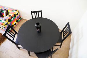 une table noire avec un vase en haut dans l'établissement Apartamento T3, à Faro