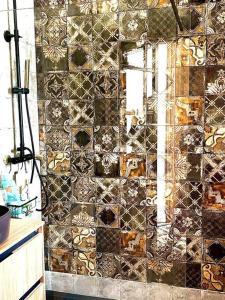 ein Bad mit einer gefliesten Wand und einem Spiegel in der Unterkunft Casa Mediterranea- Les mil i una nits in Valencia
