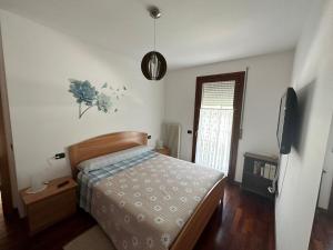 um quarto com uma cama e uma televisão em Dolce Ricordo, locazione turistica em Marano Vicentino