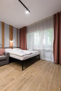 a bedroom with a bed and a couch in it at Нові затишні smart-квартири LеГо in Uzhhorod