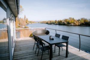 ヴィレンヌ・シュル・セーヌにあるコム アン ポアソン ダン ローのテーブルと椅子、川の景色を望むバルコニー