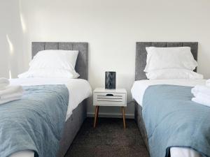 two beds sitting next to each other in a bedroom at Seaton House by Blue Skies Stays in Seaton Carew