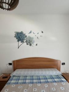 1 dormitorio con 1 cama con flores y mariposas en la pared en Dolce Ricordo, locazione turistica, en Marano Vicentino