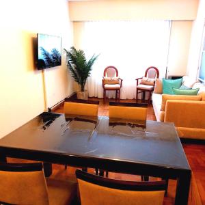 布蘭卡港的住宿－Departamento Plaza，客厅配有餐桌和椅子