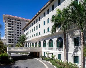 a large white building with palm trees in front of it at Condado Vanderbilt Hotel in San Juan +80 photos