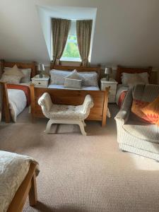 a bedroom with two beds and a chair and a window at Heeneys Lodge B&B in Donegal