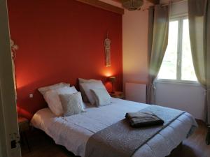 a bedroom with a bed in a red wall at Maison de campagne avec jacuzzi 
