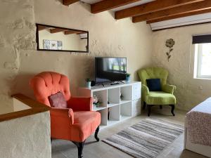 een woonkamer met een stoel en een televisie bij Le Potiron in Scheidgen