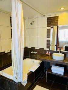 uma casa de banho com uma banheira e um lavatório em HOTEL POLO CUSCO SUITES em Cusco
