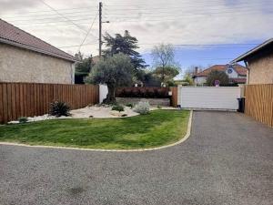 a backyard with a fence and a driveway at Logement privée in La Teste-de-Buch