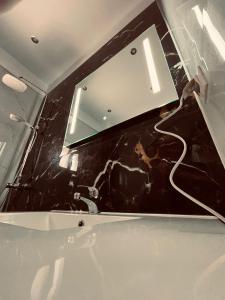 bagno con lavandino bianco e specchio di Pachmann Studios a Flogita