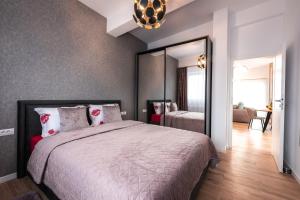 a bedroom with a large bed and a mirror at Mountain Breeze ApartTerrace in Braşov