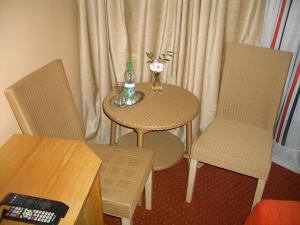 a small table with two chairs and a table with flowers on it at Kardamon in Żary