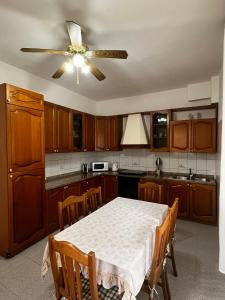 a kitchen with a table and a ceiling fan at Sempre verde in Agnone Bagni