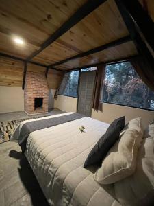 a bedroom with a large bed and a fireplace at Portocielo Cabin in La Marquesa