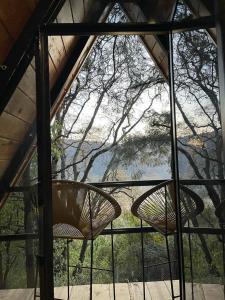 two chairs on a porch with a view of a tree at Portocielo Cabin in La Marquesa