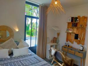 a bedroom with a bed and a table and a mirror at LA CLOSERIE DE NOINTOT in Nointot